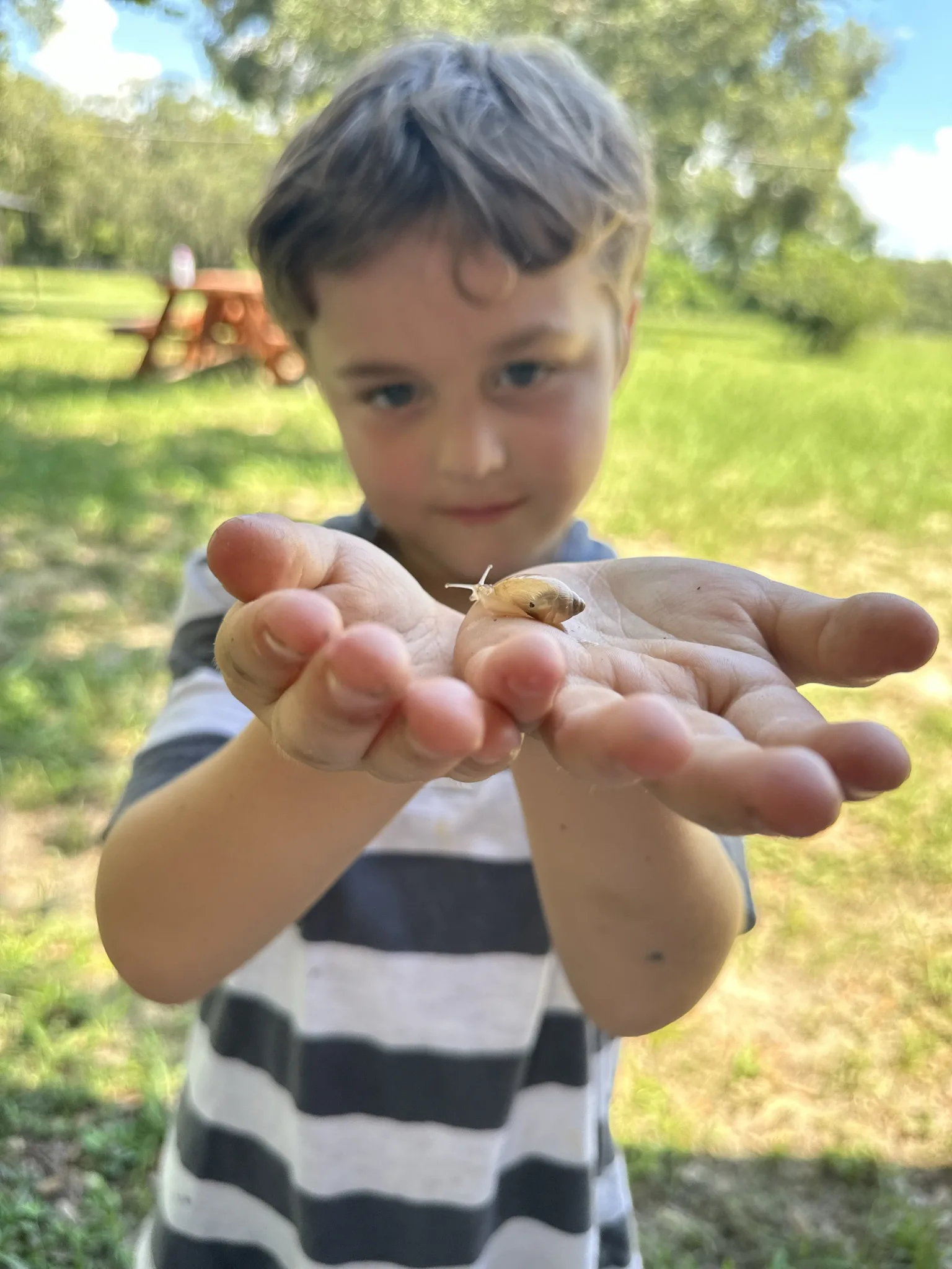 A ROC Academy student closely observing a small creature outdoors